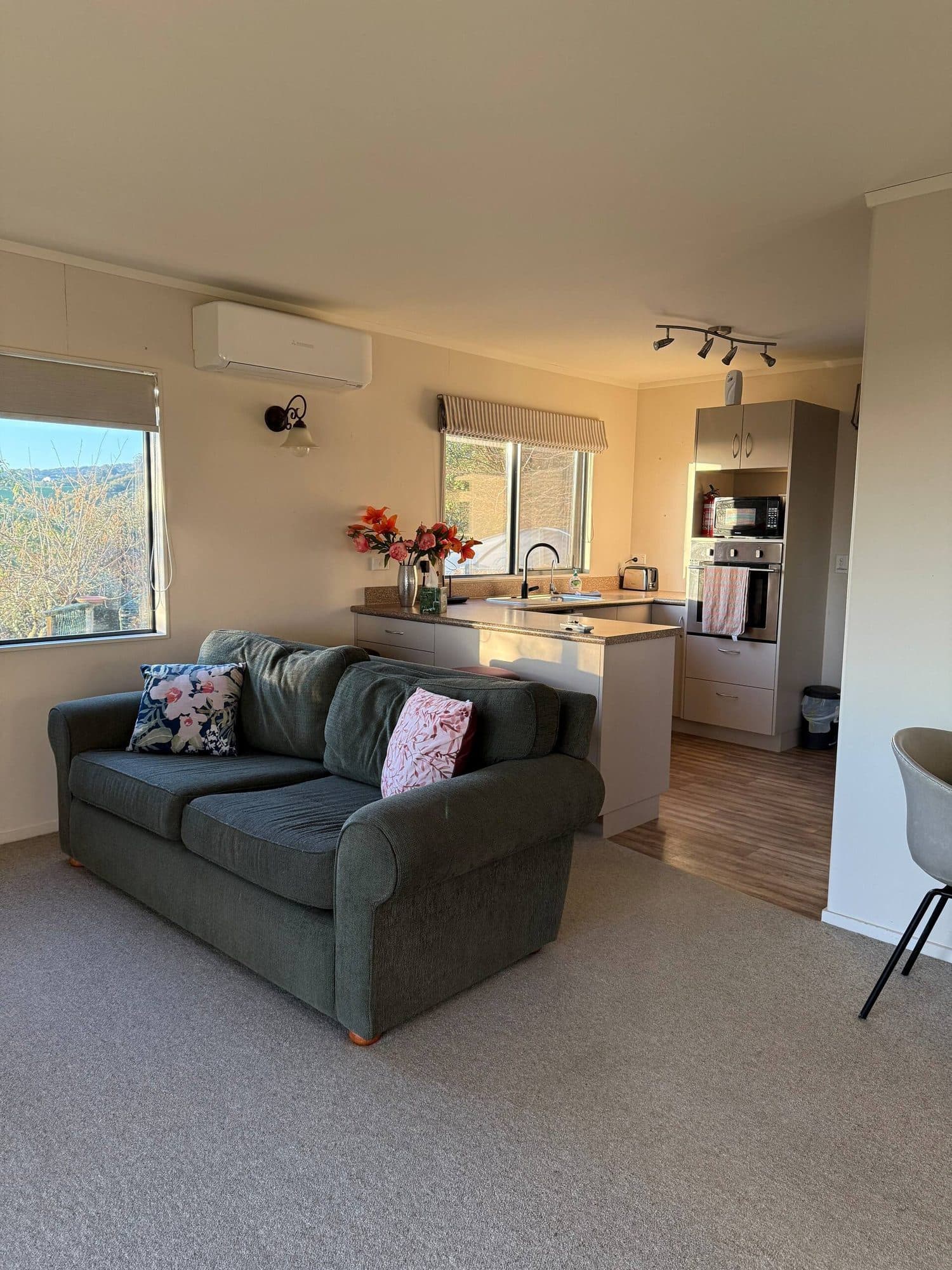 Open-plan living room opening onto the kitchen, with a window looking out to the hills