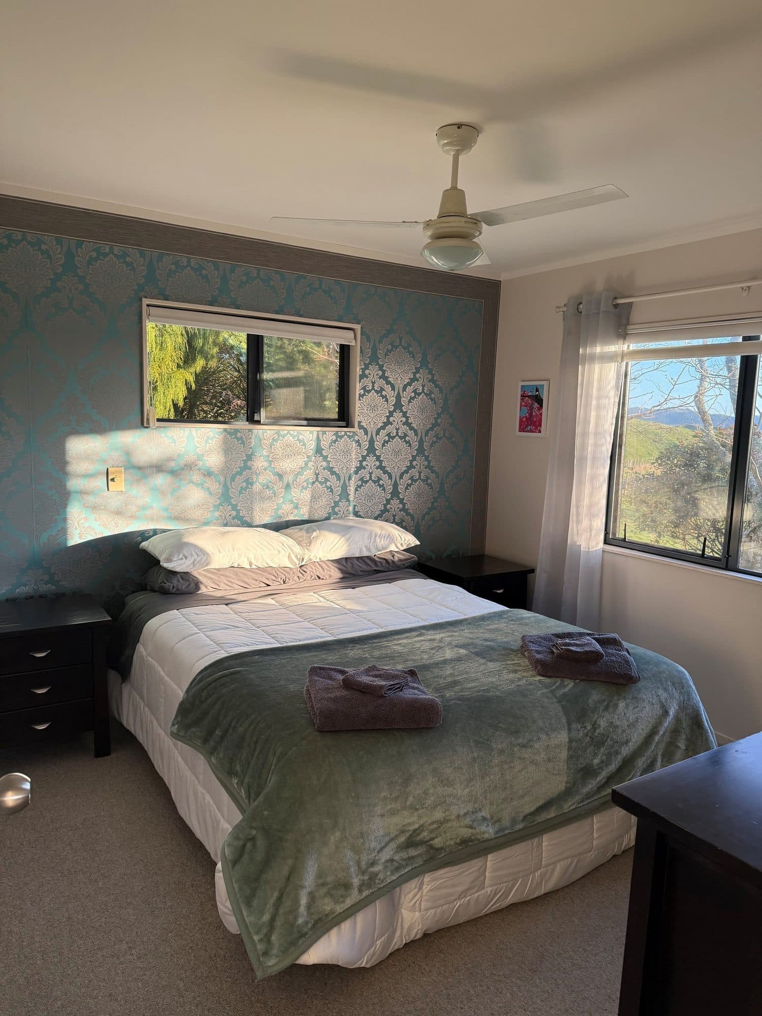 Main bedroom with a queen bed and a feature wallpaper wall